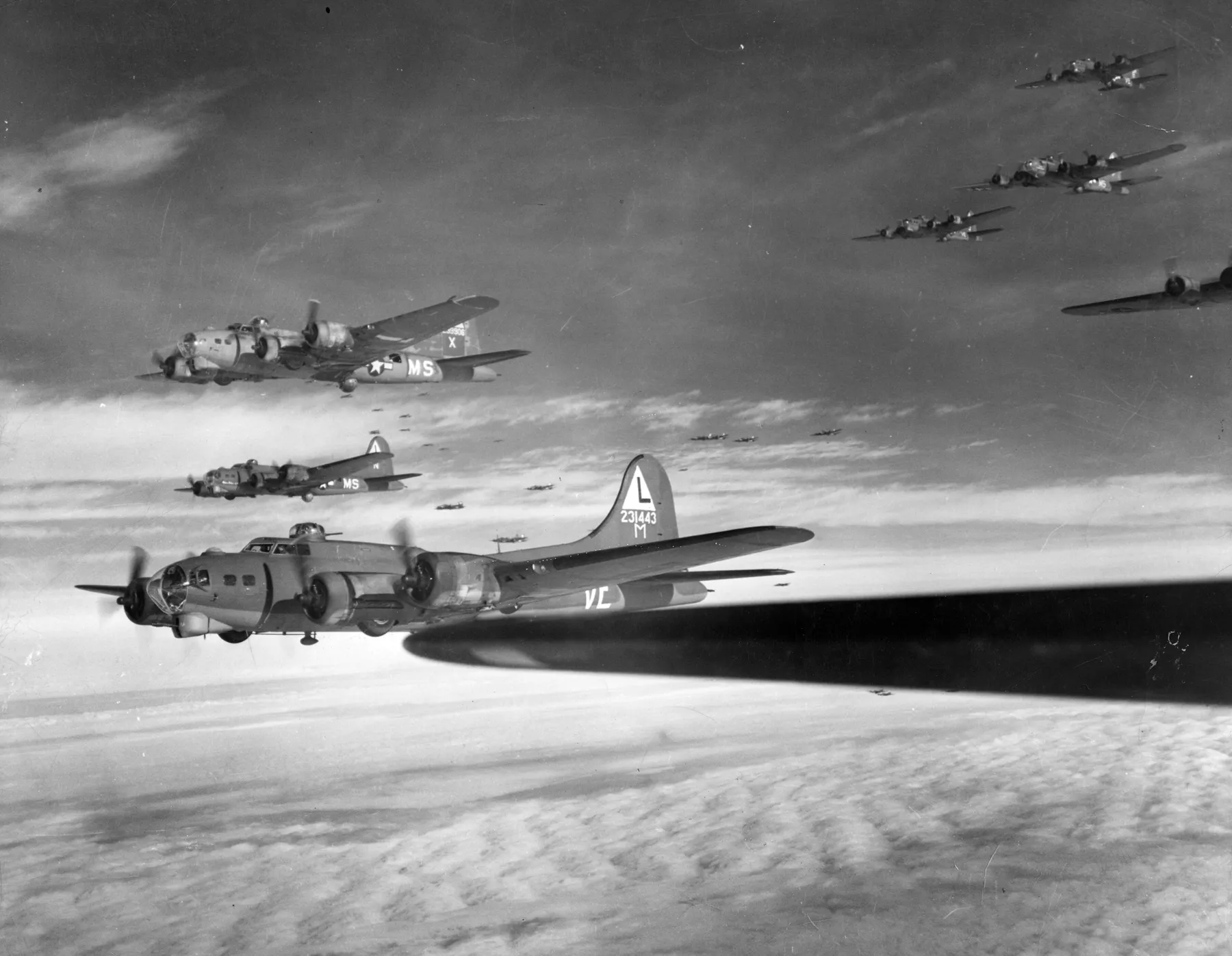 B-17G bombers flying in formation above the clouds