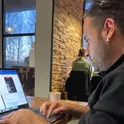 Hayati İbiş working on a laptop in a café